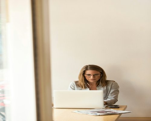 A professional taking a moment to look away from a laptop