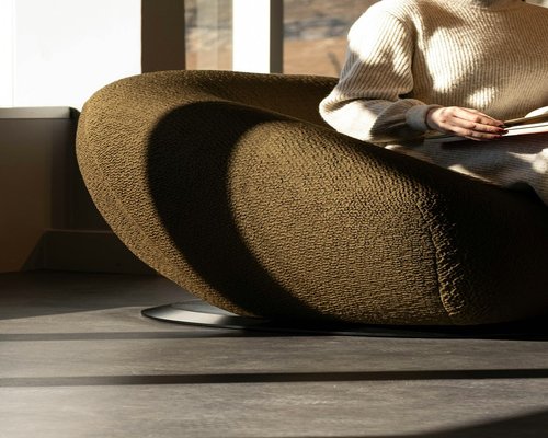 A person reading a book in a comfortable room with good lighting